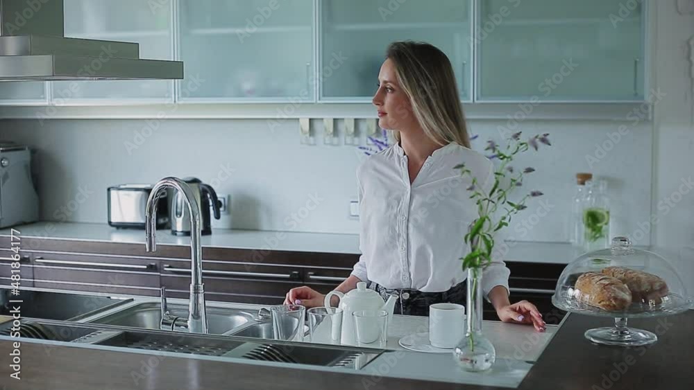 beautiful girl stands in the kitchen looks away beautiful girl stands in the kitchen looks away