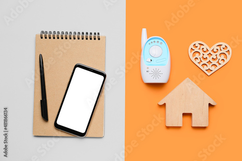 Mobile phone with office supplies, baby monitor, figure of house and heart on color background. Concept of balance