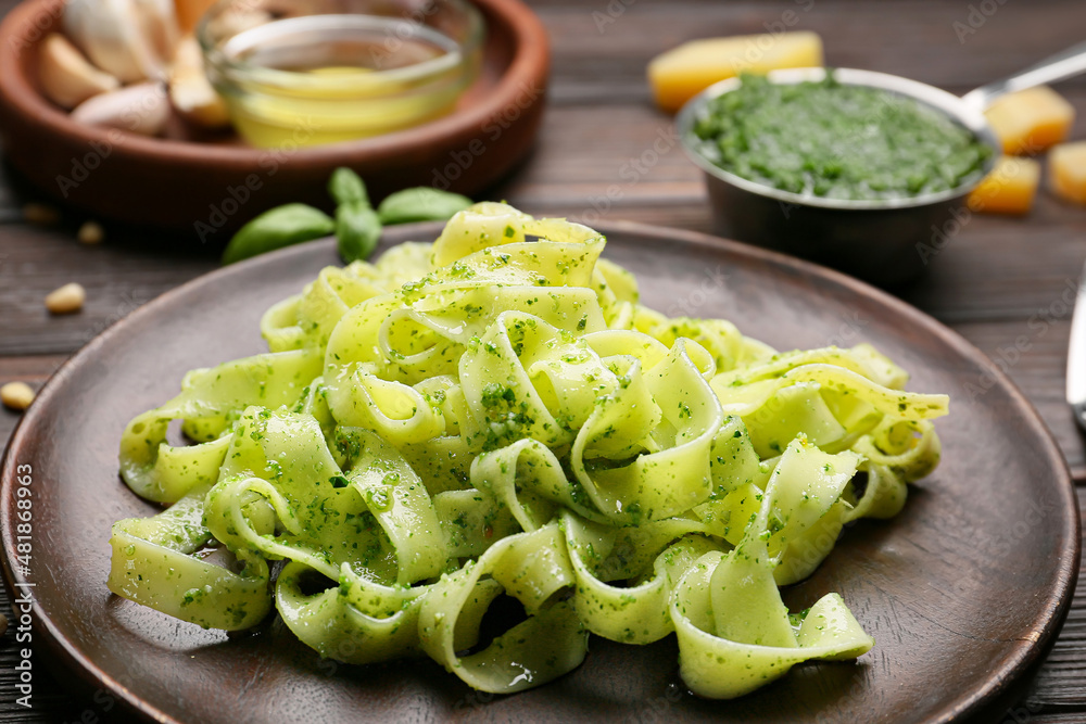 Plate of tasty pesto pasta on wooden background Plate of tasty pesto pasta on wooden background