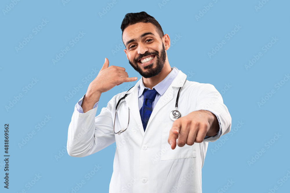 Fototapeta premium Cheerful Arab Doctor Male Gesturing Call Me On Blue Background