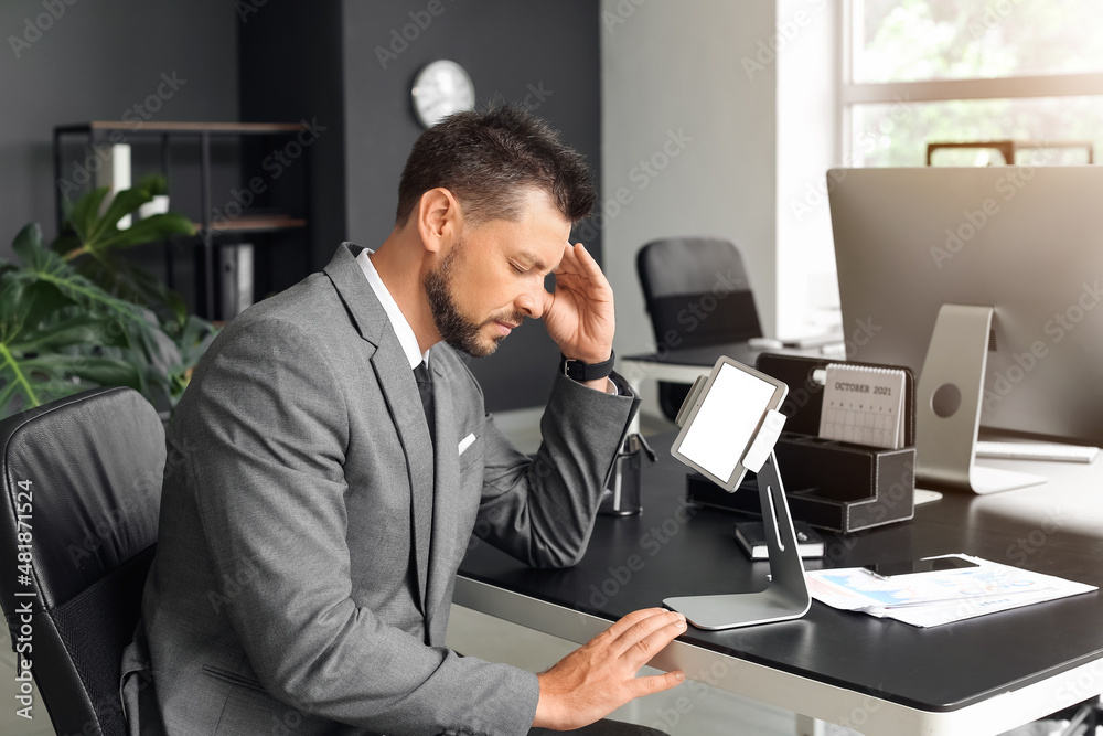 Tired young businessman working at table in office Tired young businessman working at table in office