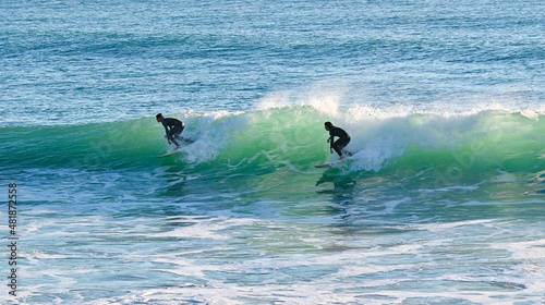 Two surfers sharing a nice wave on the Atlantic coast of south Spain in Cadiz photo