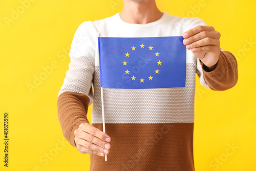 Young man with flag of European Union on color background photo