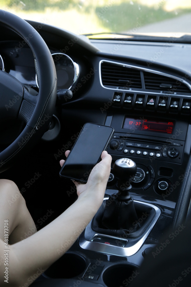 Woman is pairing her phone with car music system via bluetooth	