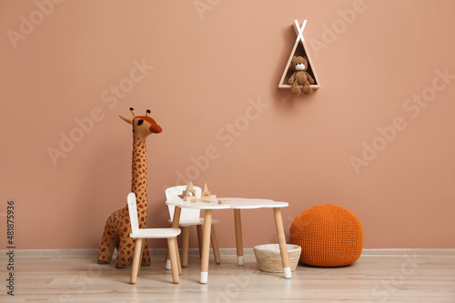 Cute child room interior with furniture  toys and wigwam shaped shelf on pink wall