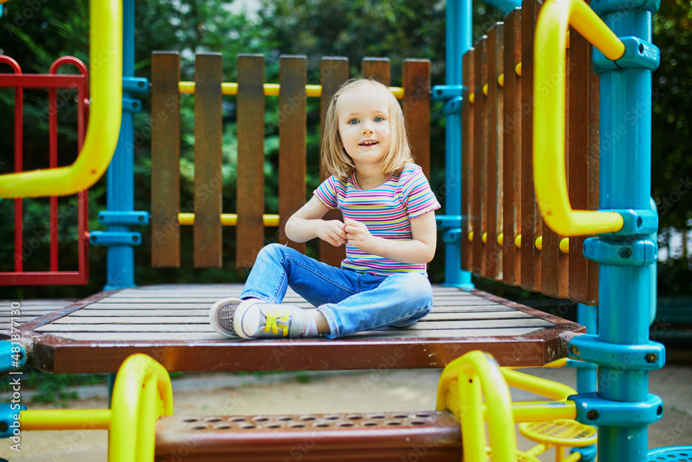 Girl on playground on a sunny day. Preschooler child playing on a slide. Outdoor activities for kids Girl on playground on a sunny day. Preschooler child playing on a slide. Outdoor activities for kids