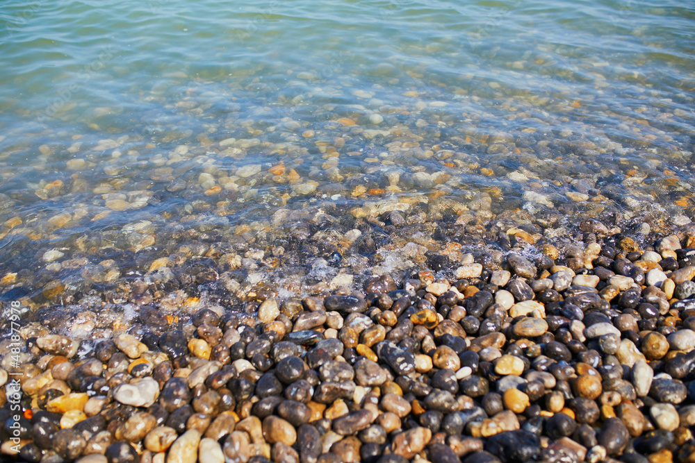 Clear water and and pebbles on a beach at Atlantic coast at Normandy, France