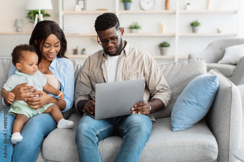 African american family using computer with baby at home