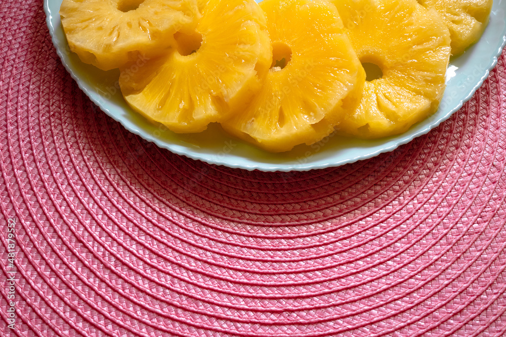 Sweet pineapple rings on a turquoise plate with empty space for your text Sweet pineapple rings on a turquoise plate with empty space for your text