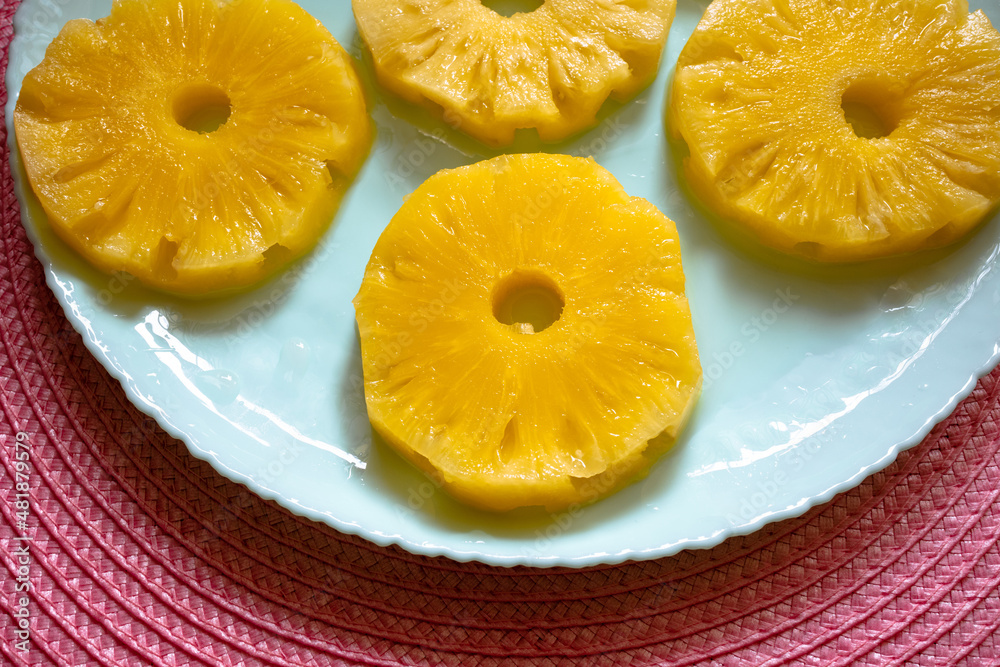 Juicy sliced pineapple on a plate. Sweet pineapple rings on a turquoise plate Juicy sliced pineapple on a plate. Sweet pineapple rings on a turquoise plate