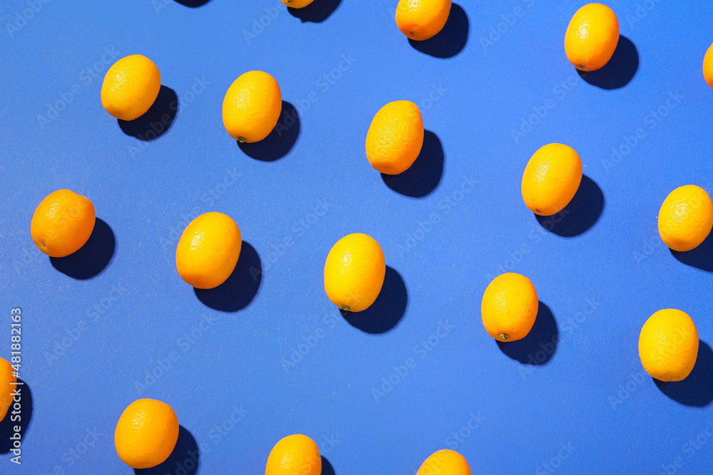 Tasty kumquat fruits on blue background Tasty kumquat fruits on blue background