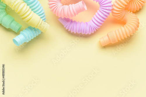 Different colorful Pop Tubes on beige background