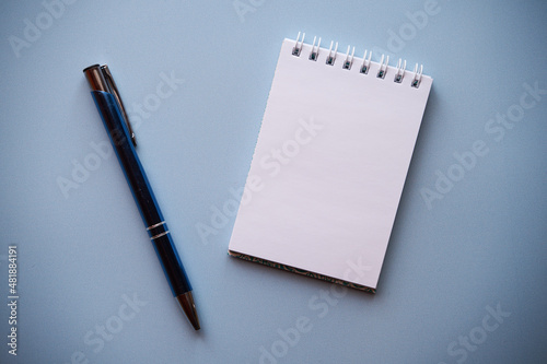 notatnik i długopis na niebieskim tle