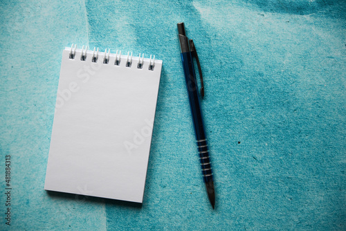 notatnik i długopis na papierowym tle 