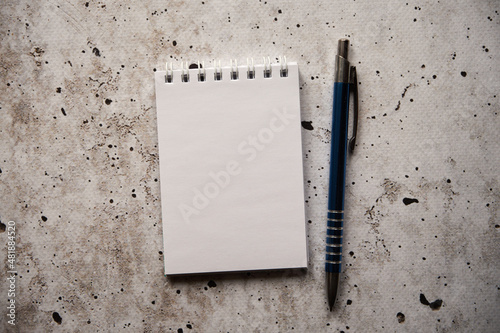 notatnik i długopis na betonie