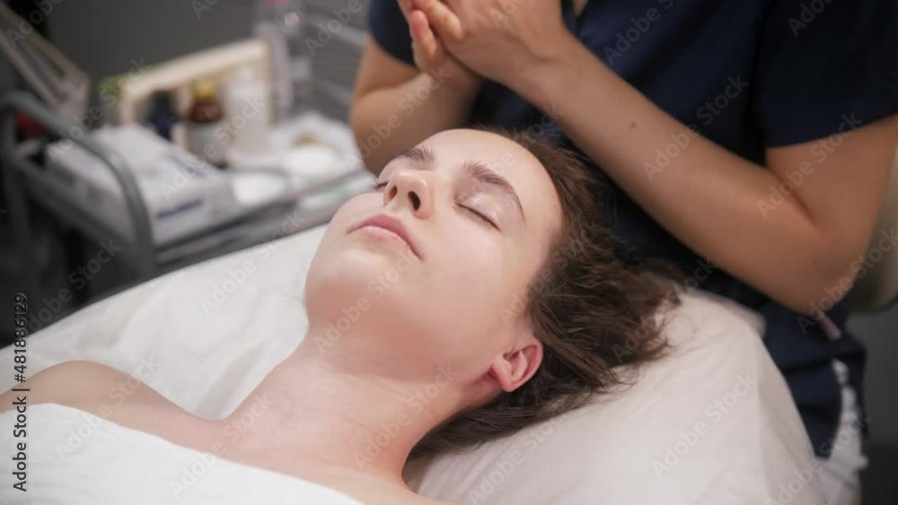 Massage session - the massagist relaxing neck of her female client and applying cream on her skin Massage session - the massagist relaxing neck of her female client and applying cream on her skin