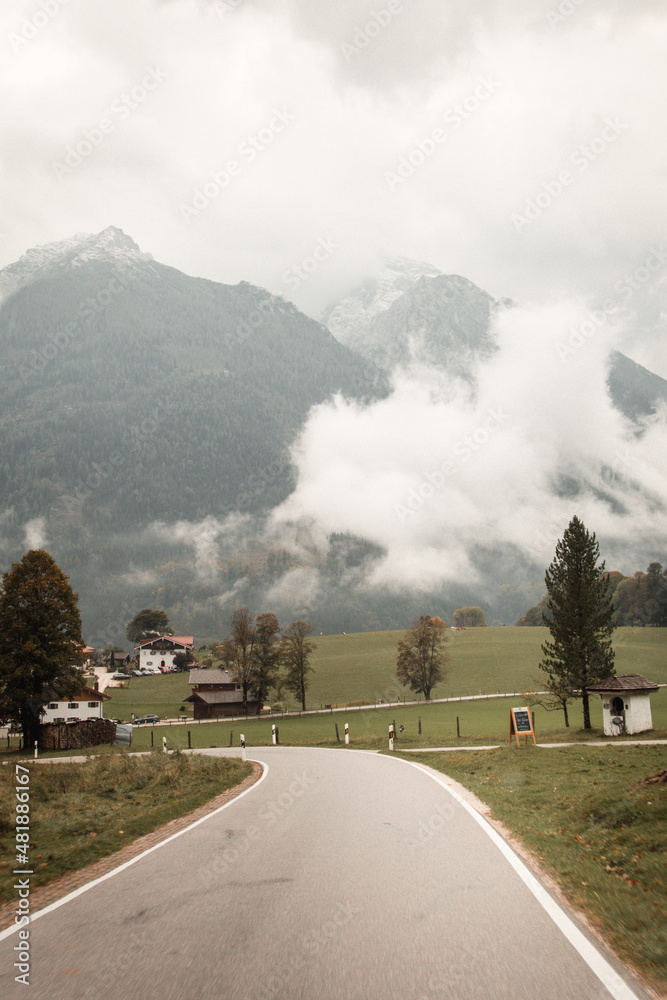 Obraz premium Beautiful village by the foggy mountains