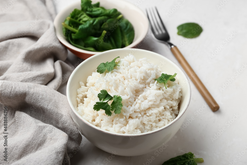 Bowl with tasty boiled rice and spinach on light background, closeup Bowl with tasty boiled rice and spinach on light background, closeup