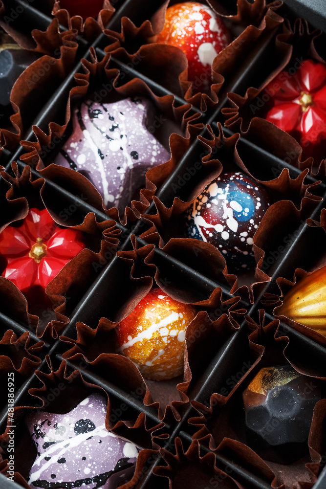 Colorful handmade chocolates in a box on a dark background Colorful handmade chocolates in a box on a dark background