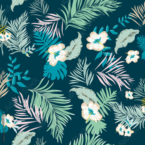 Tropical flowers and leaves on the dark green background seamless pattern