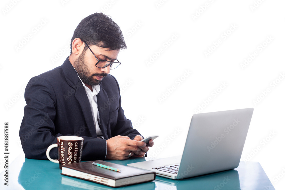 lawyer typing on cell phone in front of laptop on desk in white background lawyer typing on cell phone in front of laptop on desk in white background