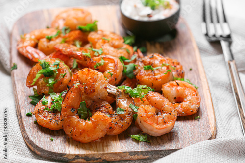 Wooden board of tasty shrimp tails on table photo