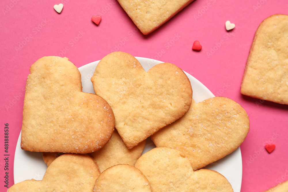 Plate with tasty heart shaped cookies on pink background, closeup. Valentines Day celebration Plate with tasty heart shaped cookies on pink background, closeup. Valentines Day celebration