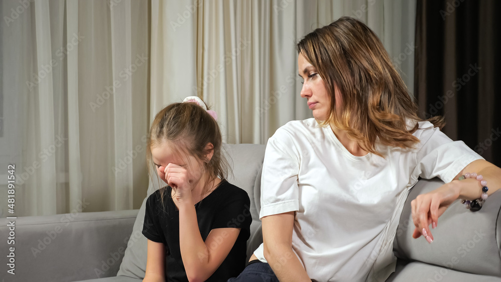 Obraz premium Teen girl complains about personal problems crying while mother trying to calm daughter hugging and stroking on sofa in living room at home.