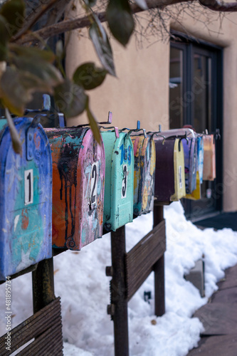 Colorful mailboxes lined in a row with snowy background © Jay