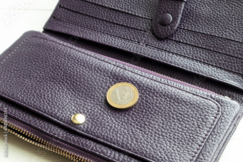 Purple zipper money wallet with a coin, on a white background. Poster.