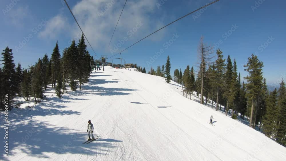 Spring Season Chairlift View of Skiers and Snowboarders on Groomed Run Spring Season Chairlift View of Skiers and Snowboarders on Groomed Run