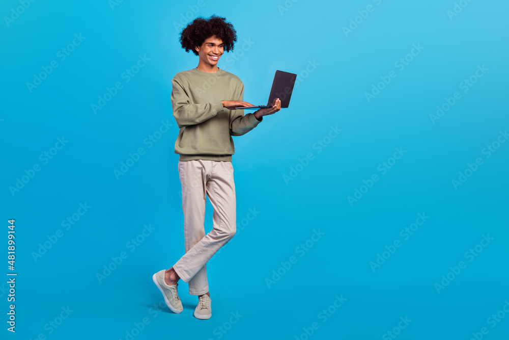 Full length photo of young guy use laptop chat type speak presentation expert isolated over blue color background
