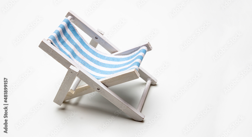 Deck chair, white blue striped beach chair isolated on white background.