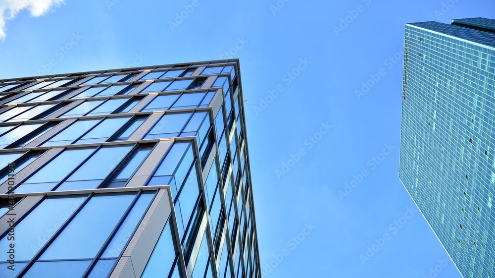 Modern glass corporate architecture with reflection of sky on the facade a sunny day - obrazy, fototapety, plakaty 