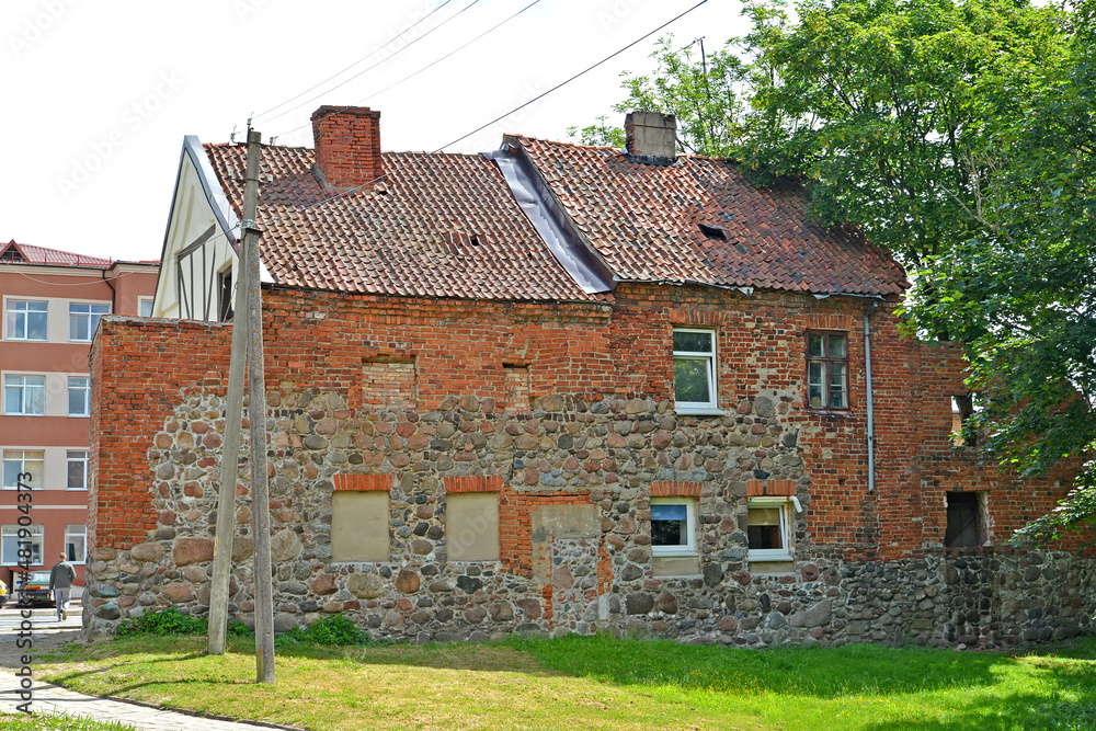 An old German-built residential building built in the remains of the fortress wall of Friedland (XIV century). Pravdinsk, Kaliningrad region