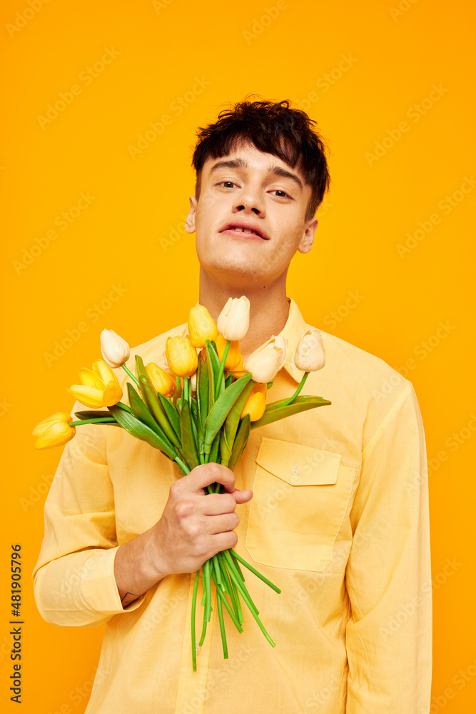 handsome guy in yellow glasses with a bouquet of flowers isolated background unaltered handsome guy in yellow glasses with a bouquet of flowers isolated background unaltered
