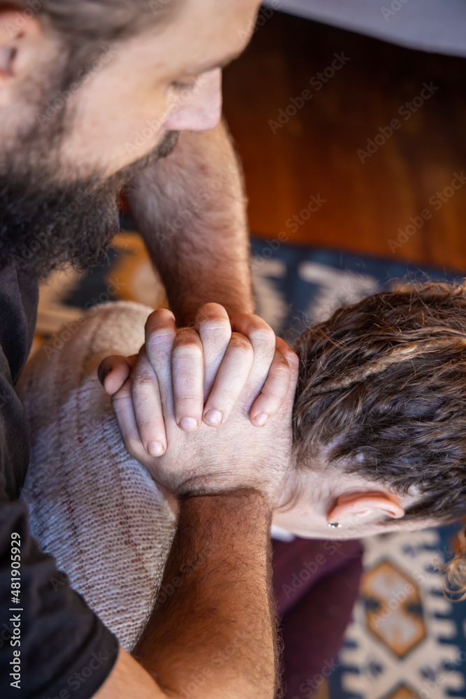 Selective focus shot during a professional massage therapy appointment. Female client is seen from above as muscular man massages back of head. Selective focus shot during a professional massage therapy appointment. Female client is seen from above as muscular man massages back of head.