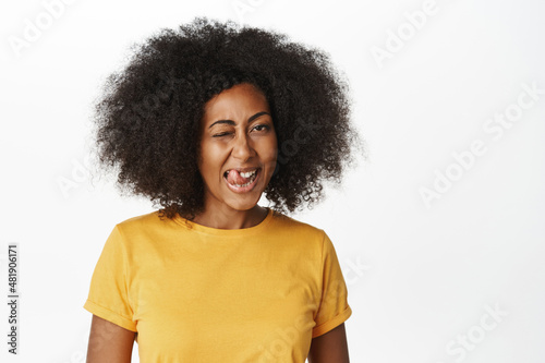 Close up portrait of beautiful african woman looking happy and carefree, showing excitement and positive emotions, standing over white background