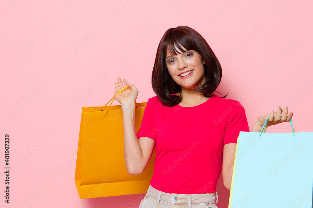 Fototapeta premium beautiful woman pink t-shirts with shopping bags cropped view