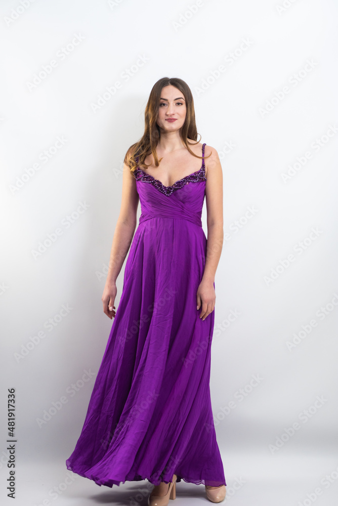 Full body portrait of gorgeous young brunette woman dressed in exquisite nude ball gown with lace top. Attractive female model in elegant strapless dress posing against white background. Full body portrait of gorgeous young brunette woman dressed in exquisite nude ball gown with lace top. Attractive female model in elegant strapless dress posing against white background.