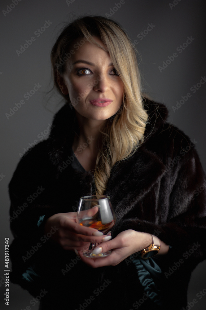 Blonde woman with glass drinking cogniac or whiskey Blonde woman with glass drinking cogniac or whiskey