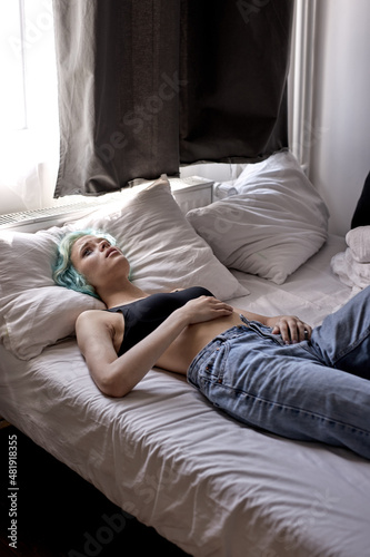 Depressed young woman lying in bed . Mental problems with depression and bulimia.Extremely depressed woman is afraid. female suffer from insomnia mental problem abuse violence concept