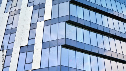 Modern glass and aluminum wall of office building outdoor with bright sun rays falling.