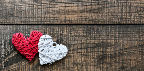 White and red heart on a wooden background.