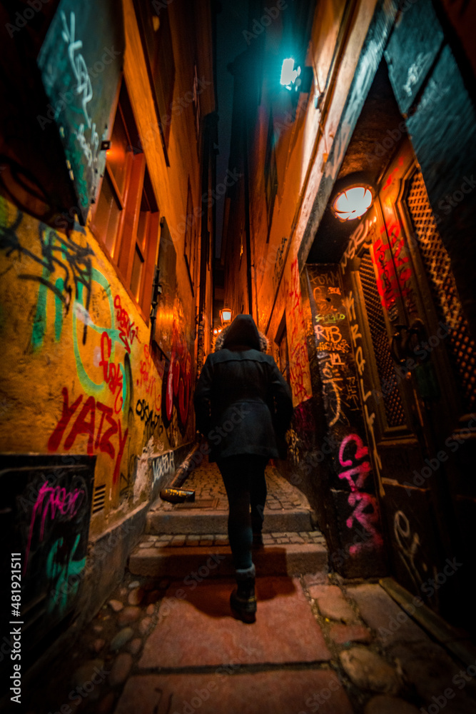 Pretty Girl in Hood Walking through Moody Dark Alley with Graffiti and Lanterns