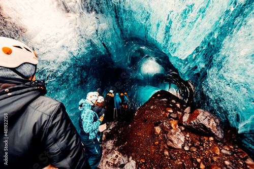 Explorer Going down Ice Cave in Iceland photo