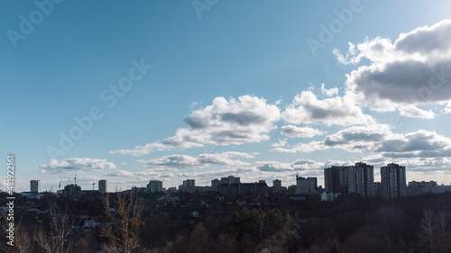 Treetop view on Kharkiv city center with Park and residential multistorey buildings with scenic bright cloudy sky
