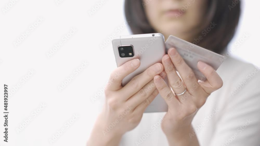 スマートフォンでオンラインショッピングをするアジア人の女性 スマートフォンでオンラインショッピングをするアジア人の女性
