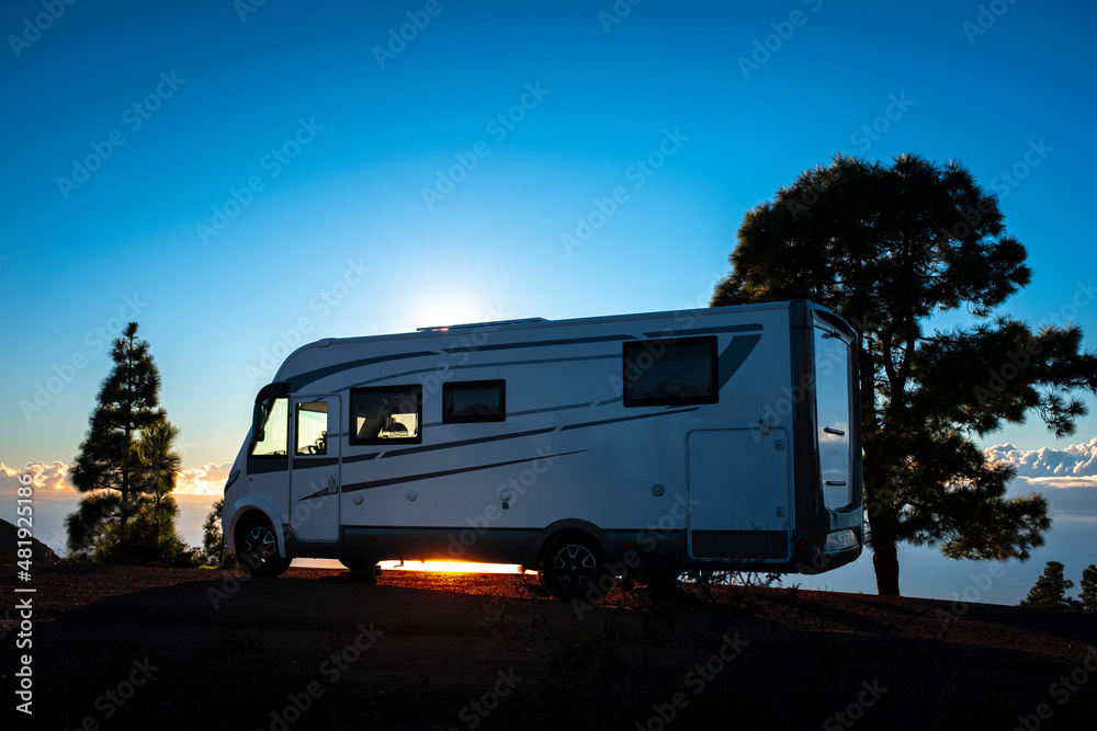 Camper van parked against sunset light and trees. Concept of alternative lifestyle vanlife and travel wanderlust. Summer holiday vacation with camping car recreational vehicle Camper van parked against sunset light and trees. Concept of alternative lifestyle vanlife and travel wanderlust. Summer holiday vacation with camping car recreational vehicle