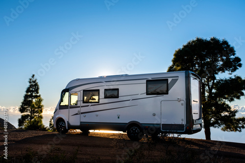 Big camper motorhome parked in off road nature space to enjoy total freedom. Off grid lifestyle vanlife. Travel with camping car and discover the beauty of the world